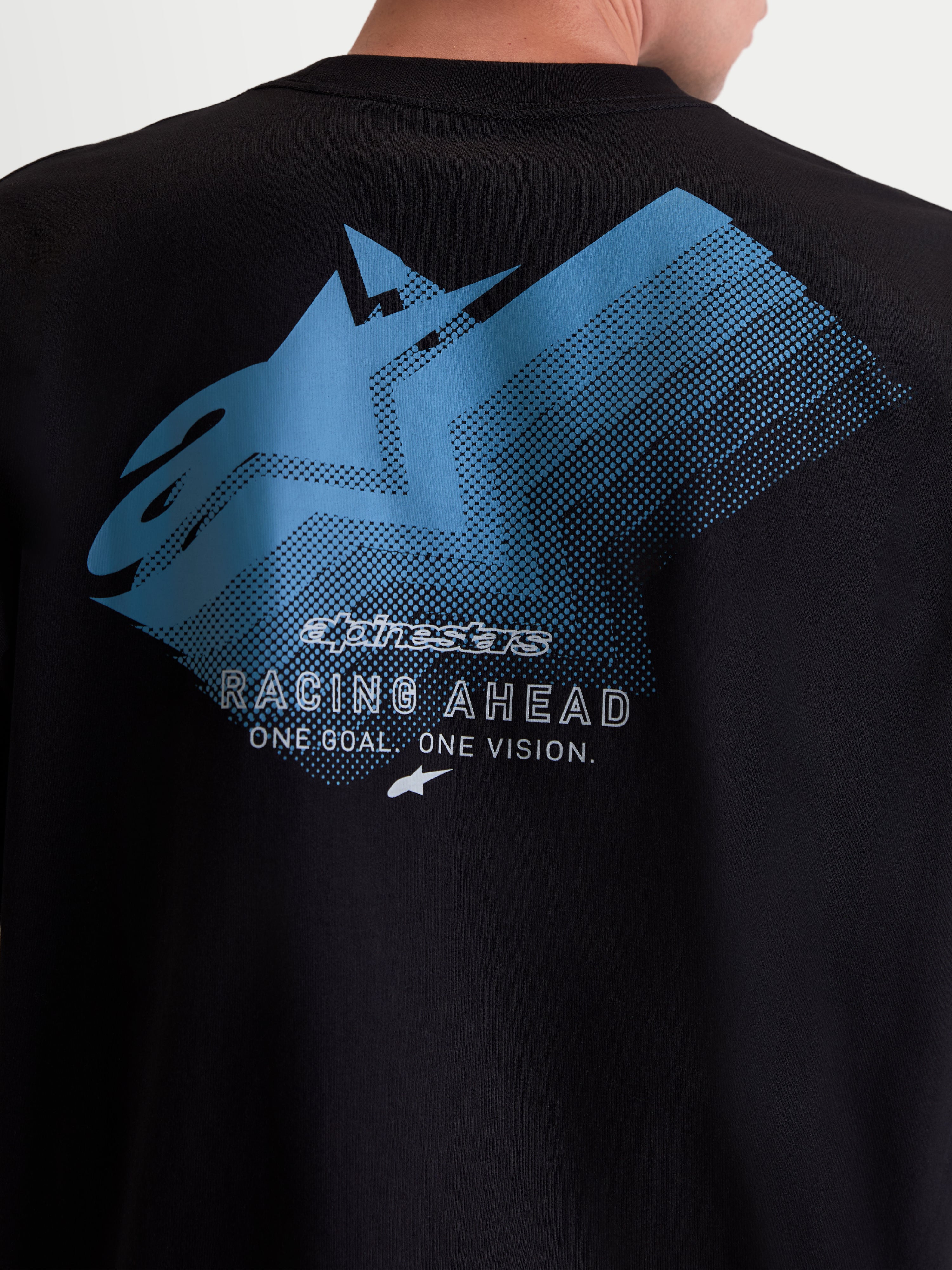 Alpinestars T-Shirt Ghost Oversized CSF, t-shirt de manga curta de sportswear, preta com grafismo traseiro azul e branco, pormenor do logótipo Astars grande com efeito esbatido e texto Racing Ahead e One Goal One Vision, vestuário de estilo motorsport, mistura de algodão e poliéster.
