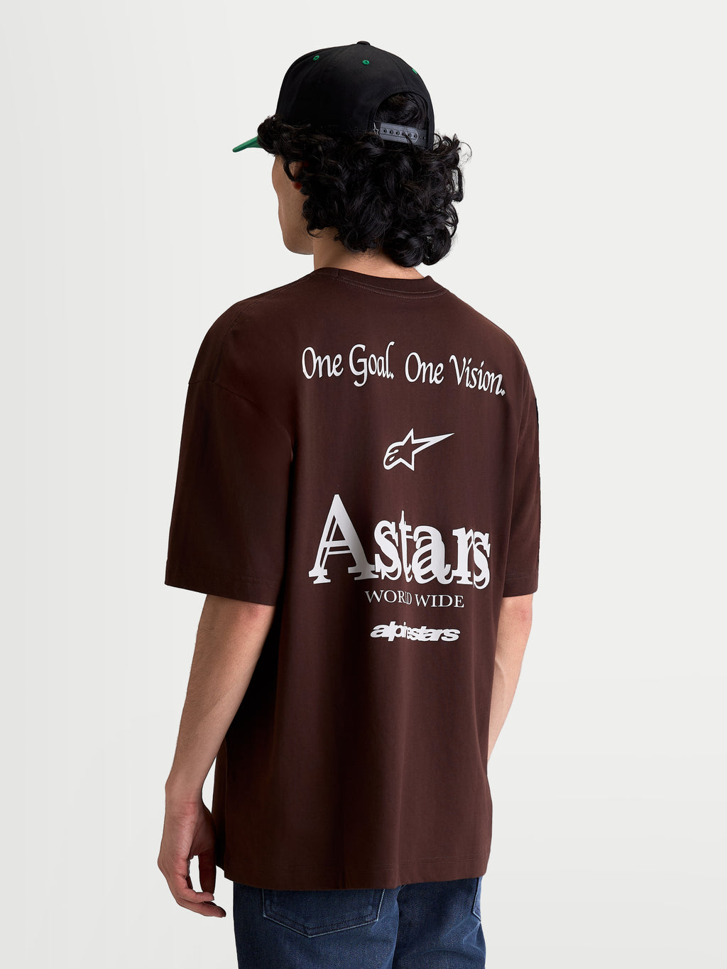 Alpinestars T-Shirt Post Oversized CSF, t-shirt de manga curta castanha, vista traseira em modelo com gráficos brancos One Goal. One Vision. e logótipo Astars, corte oversized, mistura de algodão e poliéster, casual sportswear.