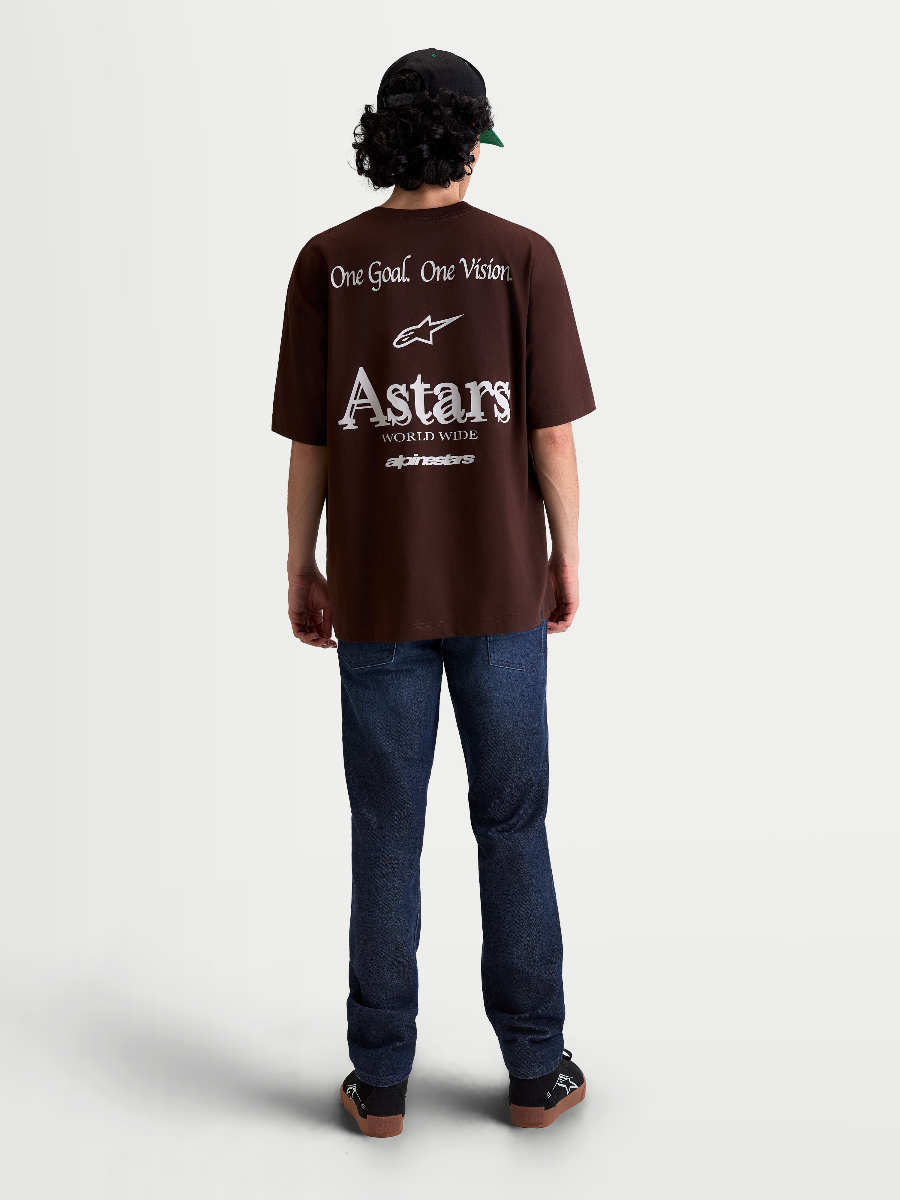 Alpinestars T-shirt Post Oversized CSF, t-shirt de manga curta unissexo castanha e branca, vista traseira com gráficos brancos 'One Goal. One Vision.' e branding Astars World Wide, corte oversized para estilo casual streetwear.