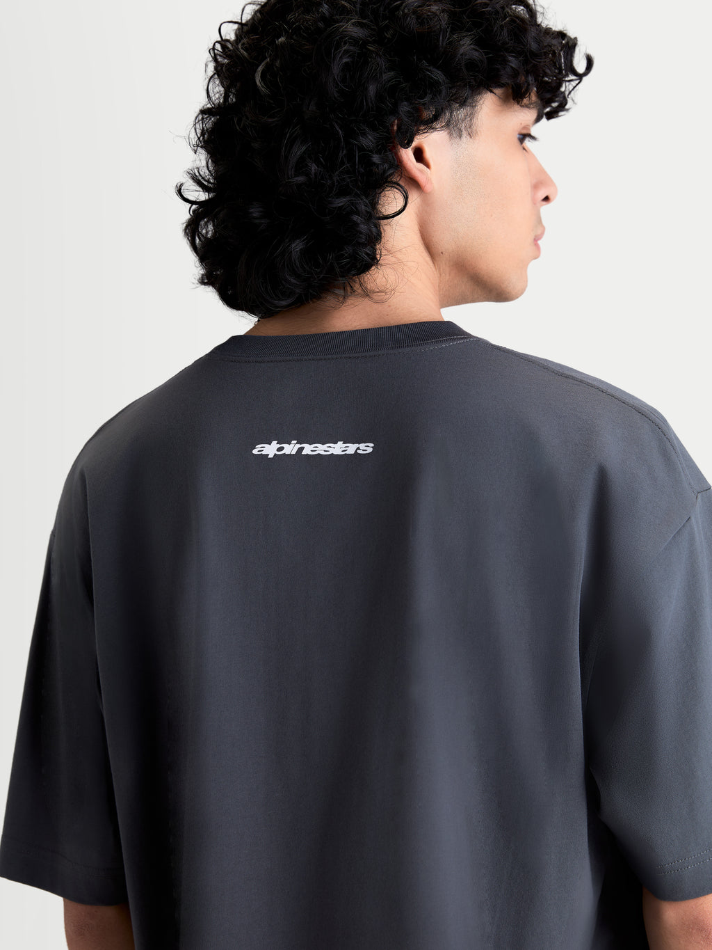 Alpinestars Mandate Oversized CSF Tee, t-shirt de manga curta unissexo cinzenta, casual sportswear, vista traseira com logótipo Alpinestars em puff print branco e corte oversized descontraído.