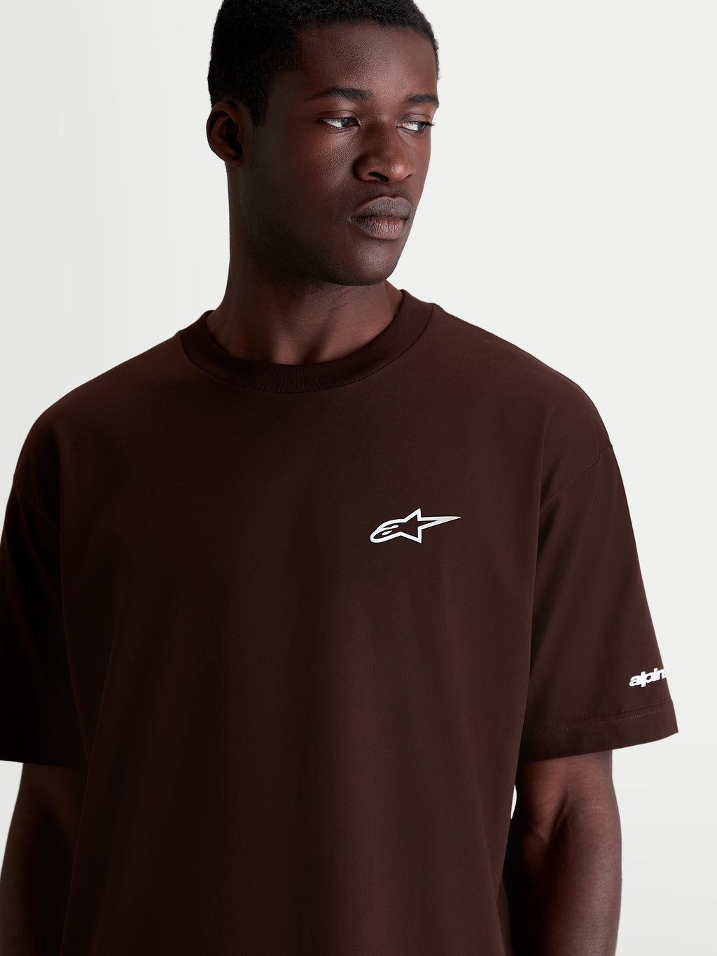 Alpinestars T-Shirt Mandate Oversized CSF, t-shirt de manga curta castanha com logótipo Astars branco no peito, casual sportswear masculino, pormenor de modelo com ajuste oversized descontraído.