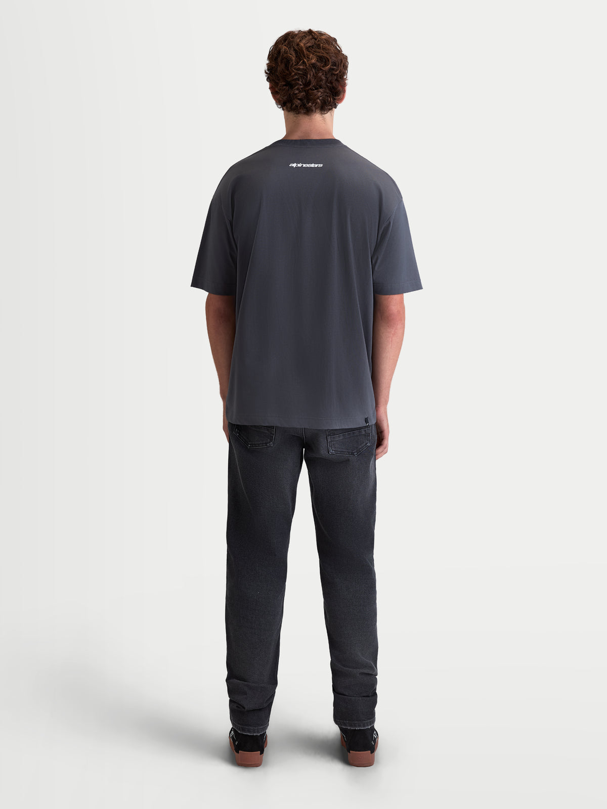 Alpinestars Prelude Oversized CSF Tee, Men's Casual Short Sleeve Sportswear T-shirt, Charcoal Gray, featuring a small white logo on the upper back, relaxed oversized fit, soft cotton-poly blend, back view on model.
