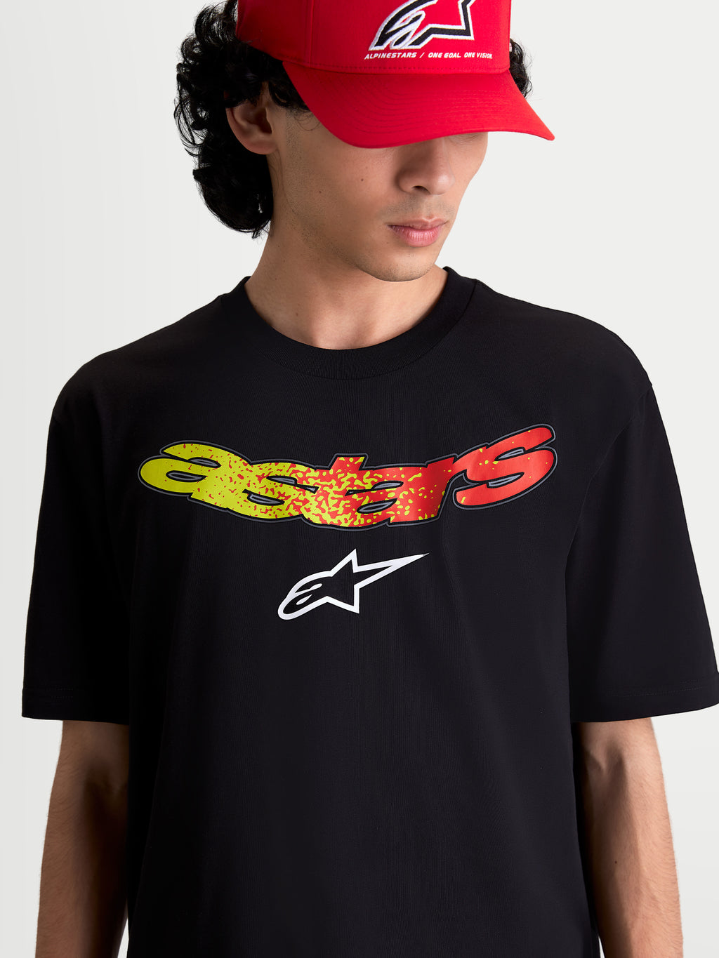 Alpinestars t-shirt Elliptogrit CSF, t-shirt de manga curta para homem, preta com grafismo frontal Astars em gradiente amarelo e vermelho, logótipo branco, casual sportswear em mistura de algodão e poliéster.