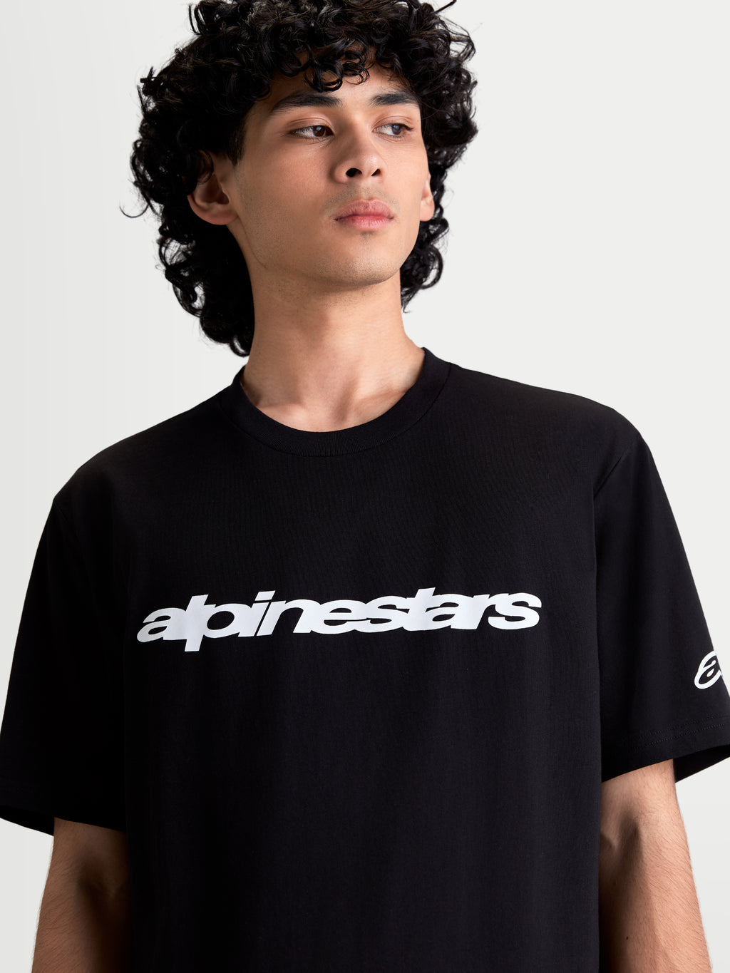 Alpinestars Race Wordmark CSF Tee, t-shirt de manga curta para homem, preta e branca, casual sportswear, modelo a usar t-shirt com gráfica frontal wordmark e logótipo na manga, mistura de algodão e poliéster.