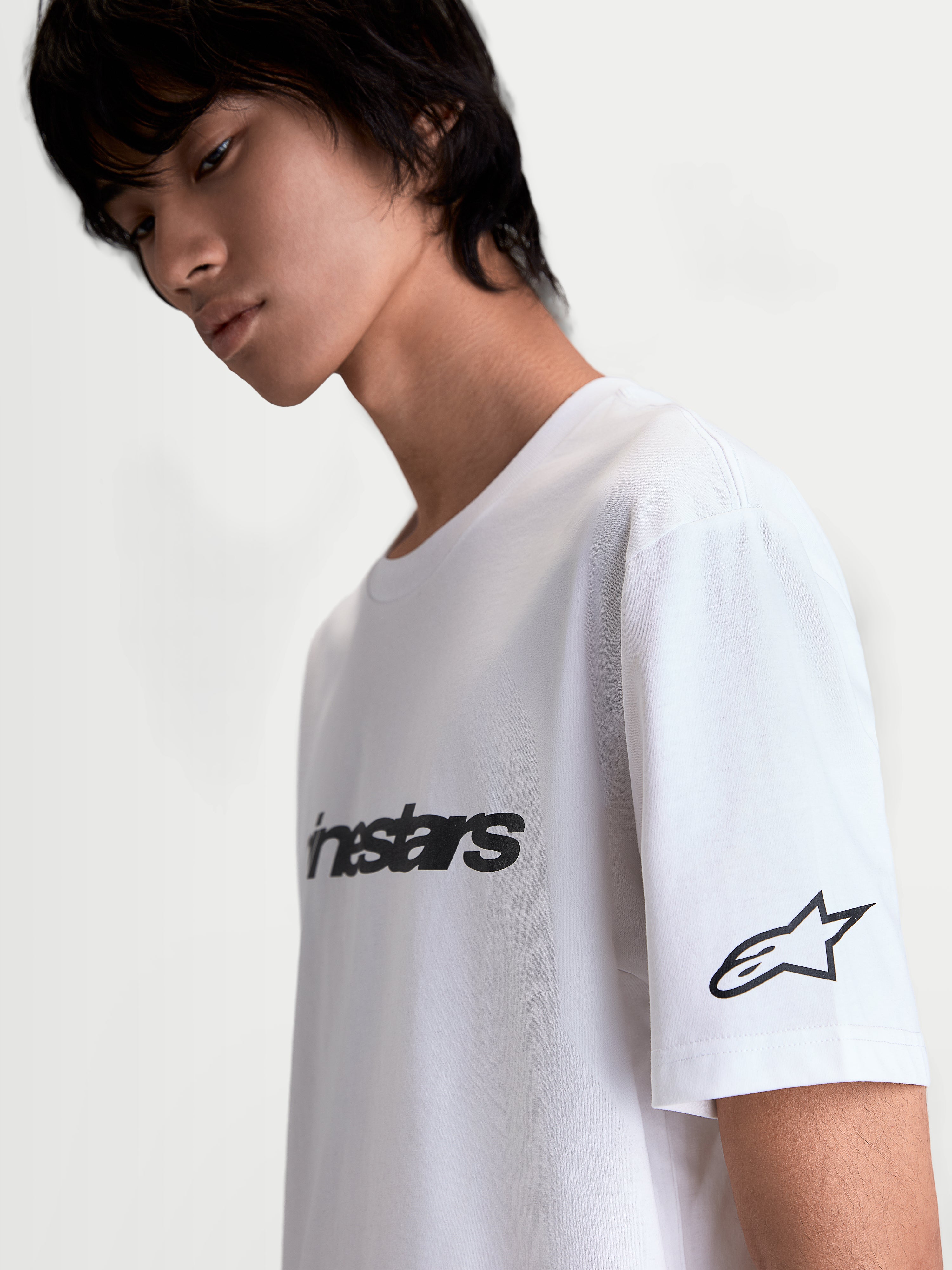 Alpinestars Race Wordmark CSF Tee, t-shirt de manga curta branca e preta, casual sportswear, com wordmark frontal, logótipo Ageless na manga e vista lateral no modelo.