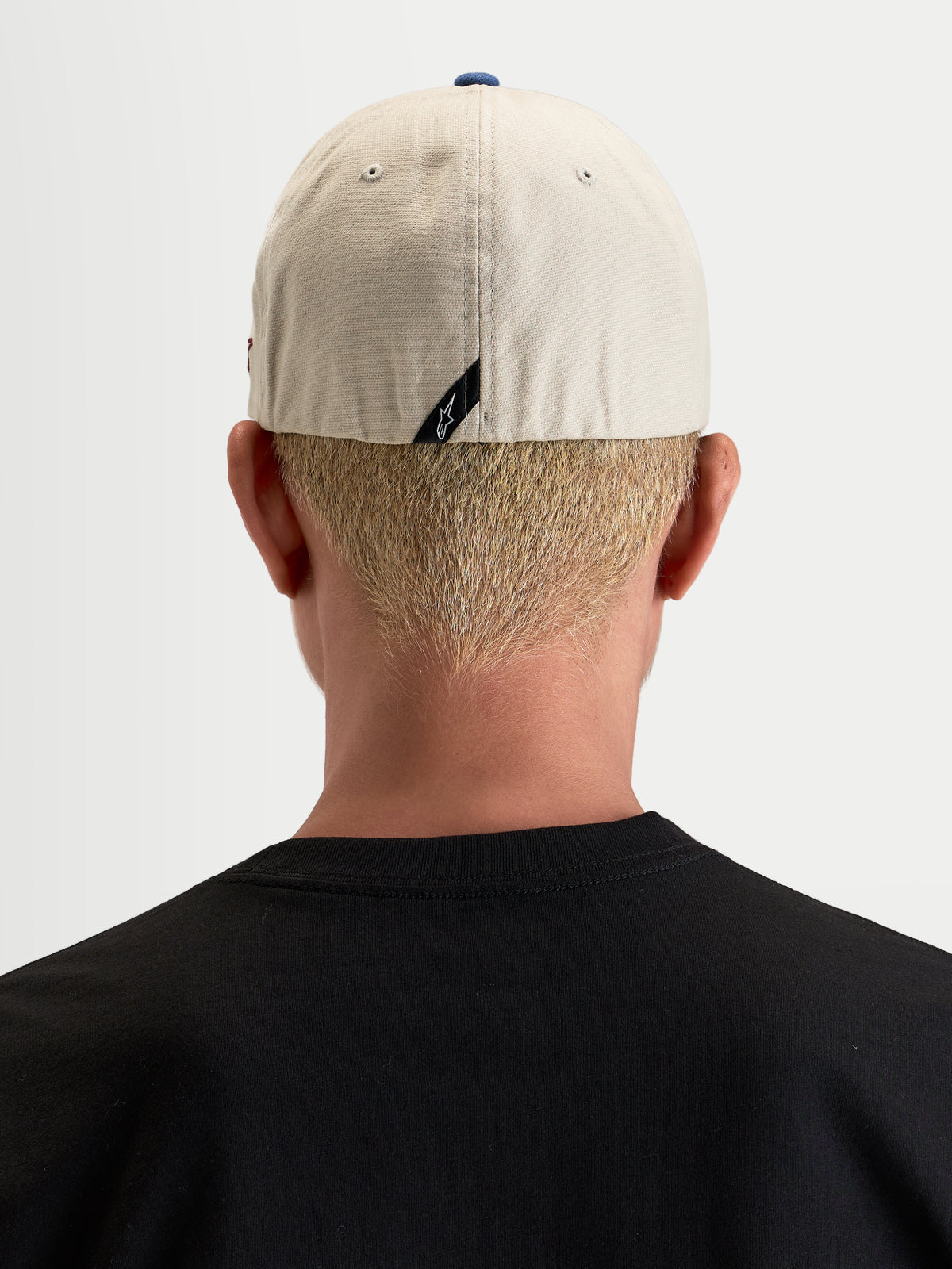 Alpinestars County Canvas Boné, boné desportivo casual, vista traseira num modelo a mostrar o ajuste flex-back e o logótipo subtil na parte traseira, areia e azul, em tecido oxford peached