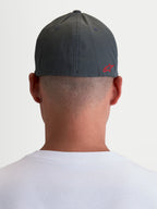 Alpinestars Chapéu Points, boné sportswear unissexo, cinzento escuro e vermelho, vista traseira num modelo com logótipo Astars HD vermelho, nylon tactel leve e ajuste flex nas costas.