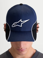Alpinestars 500 Snapback Hat, Motorsport-Inspired Sportswear Cap, Unisex, Navy Blue and Black, featuring a curved bill and 3D embroidered white Astars logo with contrast piping and cut-and-sew detailing, front view on model.