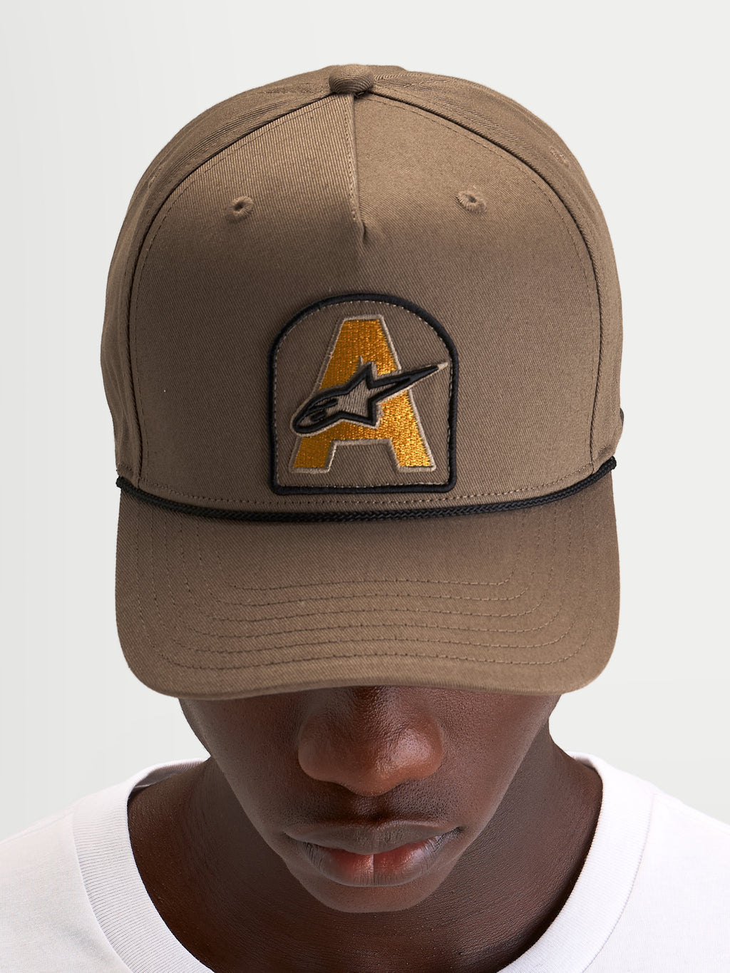 Alpinestars Boné Acme Snapback, boné desportivo de pala curva para sportswear, castanho com patch bordado frontal com logótipo Astars e detalhe de corda preta, num modelo