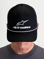 Alpinestars Boné Combo Logo Snapback, boné de sportswear casual unissexo, preto e branco, com logótipo Astars bordado e corda decorativa branca, aba curva e coroa estruturada em sarja de algodão, modelo a usar o artigo.