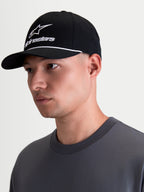 Boné Alpinestars Combo Logo Snapback, boné de sportswear em preto e branco, com pala curva, coroa estruturada, bordado branco do logótipo Astars e detalhe de cordão, mostrado num modelo em vista de perfil.