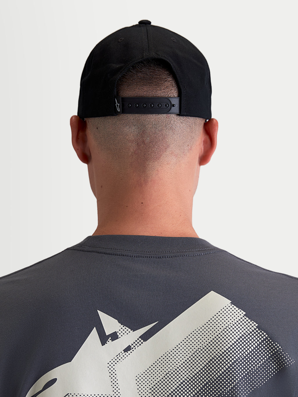 Alpinestars Boné Combo Logo Snapback, boné sportswear unissexo, preto, em sarja de algodão durável, vista traseira num modelo destacando o fecho snapback ajustável e pequeno logótipo branco.