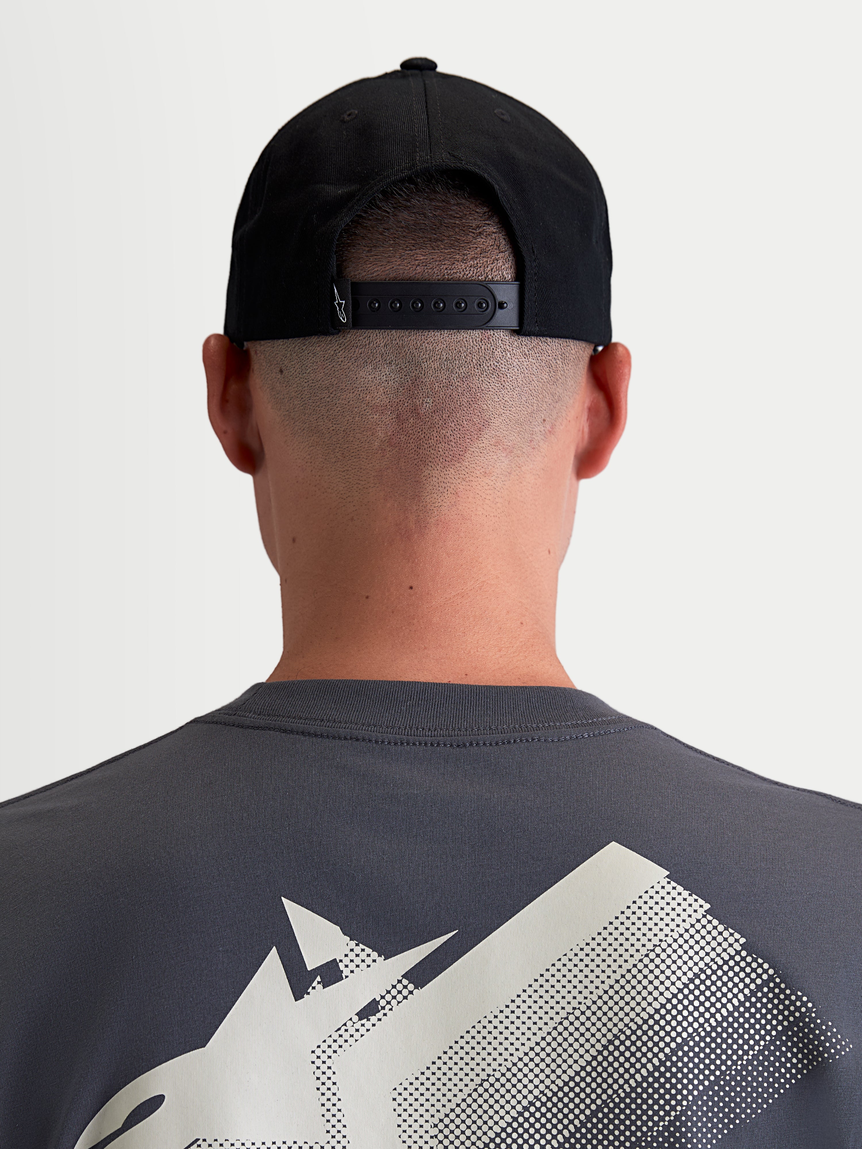 Alpinestars Boné Combo Logo Snapback, boné sportswear unissexo, preto, em sarja de algodão durável, vista traseira num modelo destacando o fecho snapback ajustável e pequeno logótipo branco.