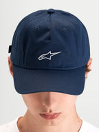 Alpinestars Boné Dad Dylan, boné desportivo casual usado por um modelo, azul com aba curva e logótipo Astars branco bordado na frente
