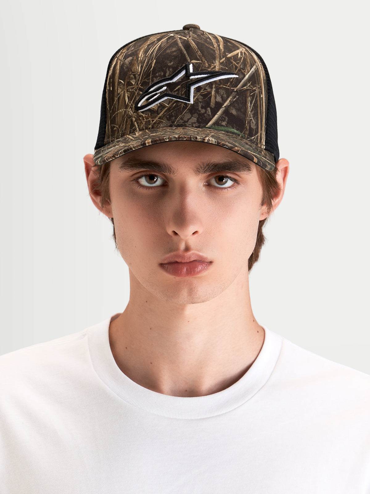 Alpinestars Thicket Realtree Boné Trucker, boné trucker sportswear em camuflado e preto, com coroa estruturada e logótipo Astars bordado à frente, usado por um modelo