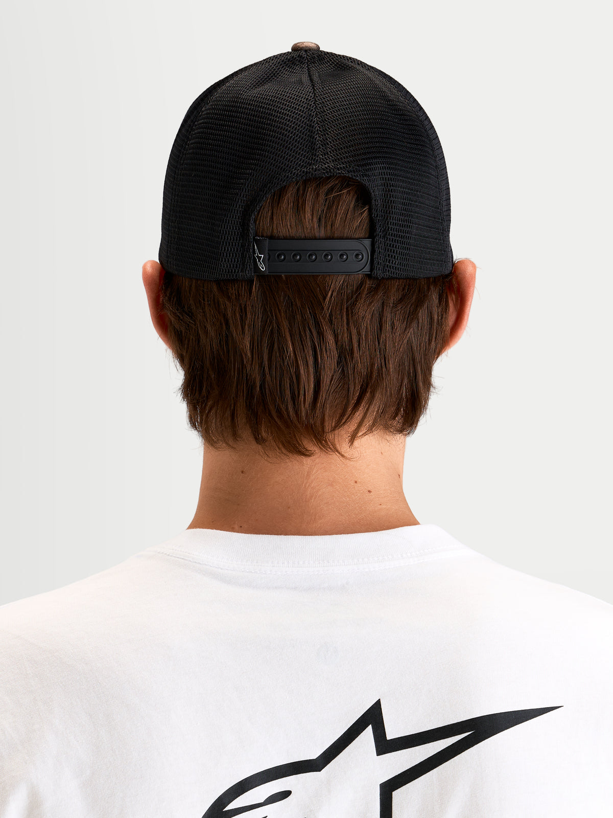 Alpinestars Boné Trucker Thicket Realtree, boné sportswear snapback, costas em malha preta, vista traseira num modelo a mostrar o fecho snapback ajustável e o logótipo Astars bordado