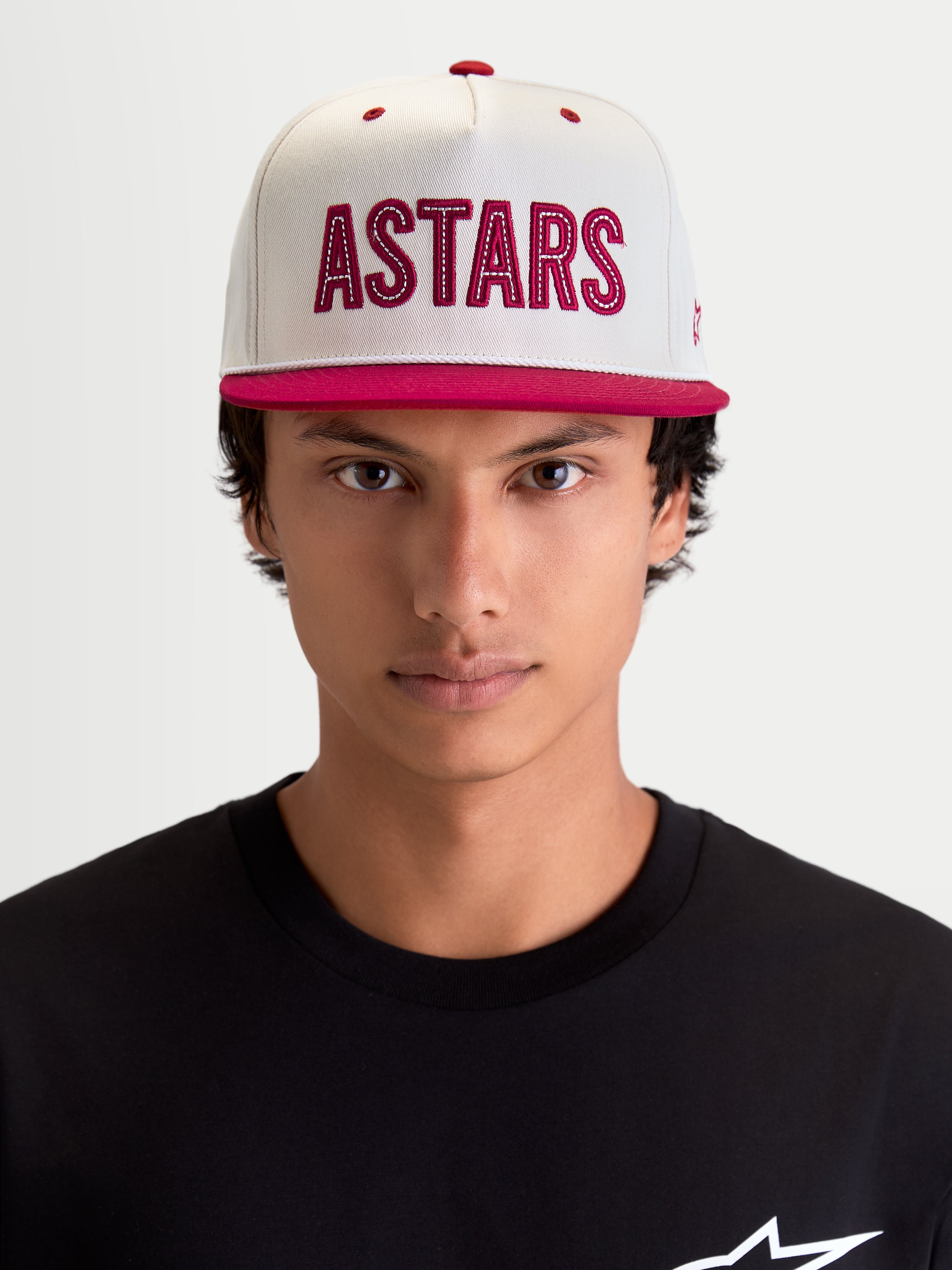 Alpinestars Stadium Snapback, boné de casual sportswear para homem, branco e vermelho, vista frontal no modelo com aba plana, coroa estruturada e aplique do logótipo ASTARS vermelho com costura contrastante.