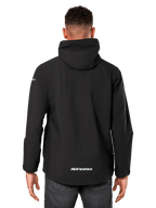 Alpinestars Kascade Rain Jacket, casaco impermeável para homem, preto, vista traseira com capuz fixo e logótipo Alpinestars na zona inferior das costas, vestuário desportivo impermeável casual