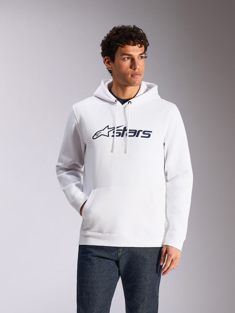 Alpinestars Blaze V3 Hoodie, streetwear casual, branca com logótipo Alpinestars em azul marinho, capuz com cordão, mangas compridas, usada com calças de ganga escuras, design moderno inspirado no desporto motorizado