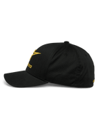 Boné Alpinestars Gild, vista de perfil lateral de um boné de basebol preto com aba curva, logótipo com bordado metálico 3D dourado na frente e na lateral, coroa estruturada e tecido de sarja elástica, vestuário desportivo casual de desportos motorizados.