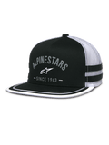 Alpinestars Backline Trucker Hat, black twill front and white mesh back, flat bill with white suttache trim on the edge, grey arched Alpinestars logo with Since 1963 text, side applique stripes, casual motorsport-inspired snapback cap