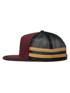 Boné Trucker Alpinestars Backline, vista de perfil lateral, Brick Black e Mustard, frente em sarja bordeaux com traseira em malha preta, apresentando riscas horizontais mostarda na lateral, pala plana com acabamento em passamanaria preta, snapback casual de inspiração motorsport