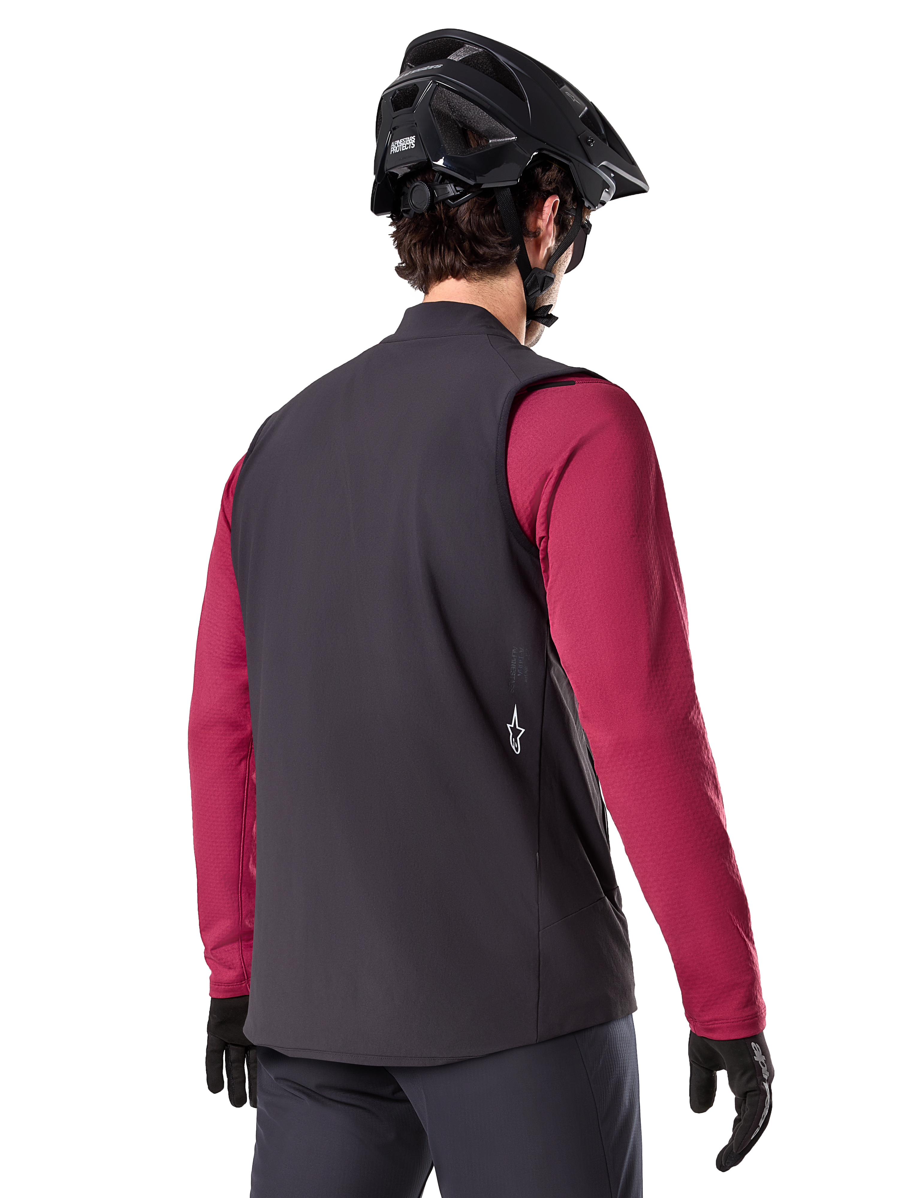 Alpinestars A-Dura Thermal Vest, Black, back view, worn over a maroon long-sleeve jersey with a black mountain bike helmet and gloves, lightweight insulated cycling gear for off-road riding