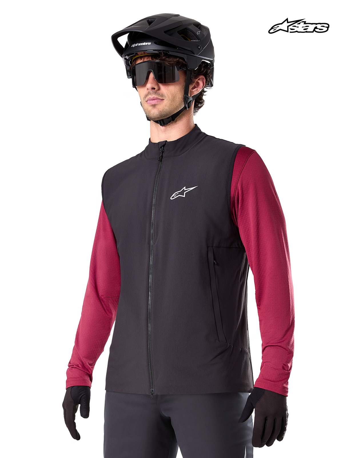 Alpinestars A-Dura Térmico colete, colete térmico de ciclismo de montanha para homem em preto, usado por um modelo com capacete e camisola de manga comprida vermelha, isolamento para BTT em tempo frio