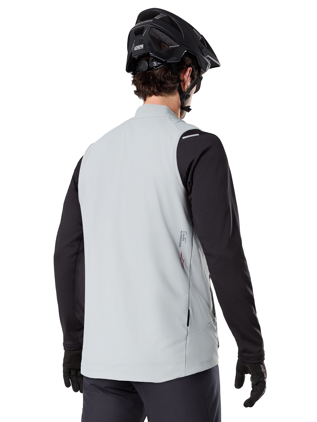 Alpinestars A-Dura Thermal Vest, Cinzento Titanium, vista traseira do modelo a usar uma camisola de manga comprida preta e capacete de BTT, design minimalista com pequeno logótipo de estrela vermelha nas costas, colete de ciclismo leve e isolado para condução fora de estrada