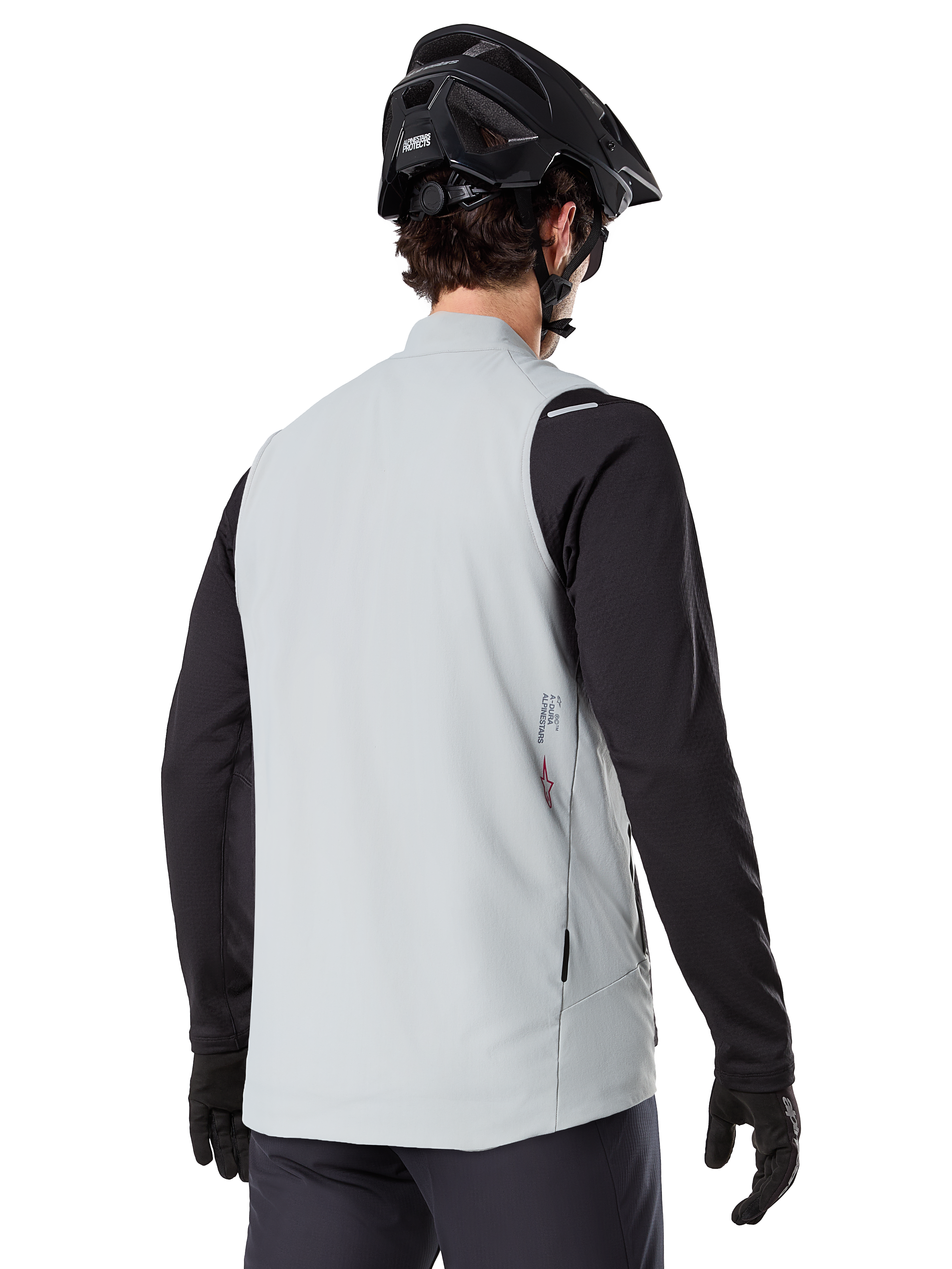 Alpinestars A-Dura Thermal Vest, Cinzento Titanium, vista traseira do modelo a usar uma camisola de manga comprida preta e capacete de BTT, design minimalista com pequeno logótipo de estrela vermelha nas costas, colete de ciclismo leve e isolado para condução fora de estrada