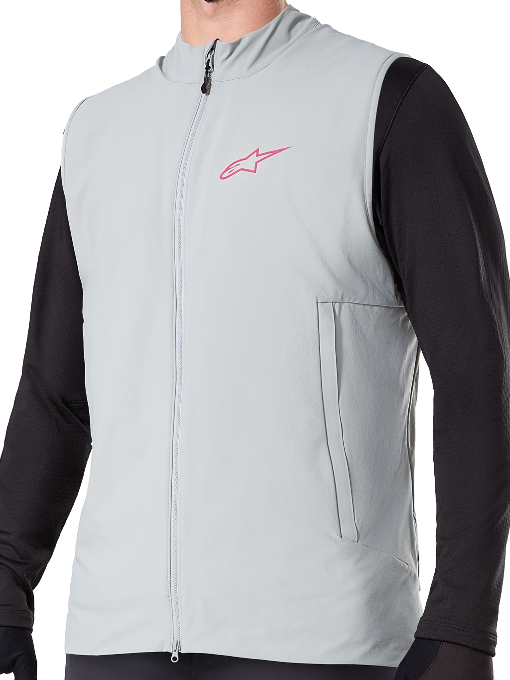 Alpinestars A-Dura Thermal Vest, colete de ciclismo isolado em cinzento Titanium, com logótipo de estrela cor-de-rosa no peito, usado sobre uma camisola preta de manga comprida, inclui um bolso vertical com fecho e fecho frontal completo, concebido para trilhos de BTT em climas frios