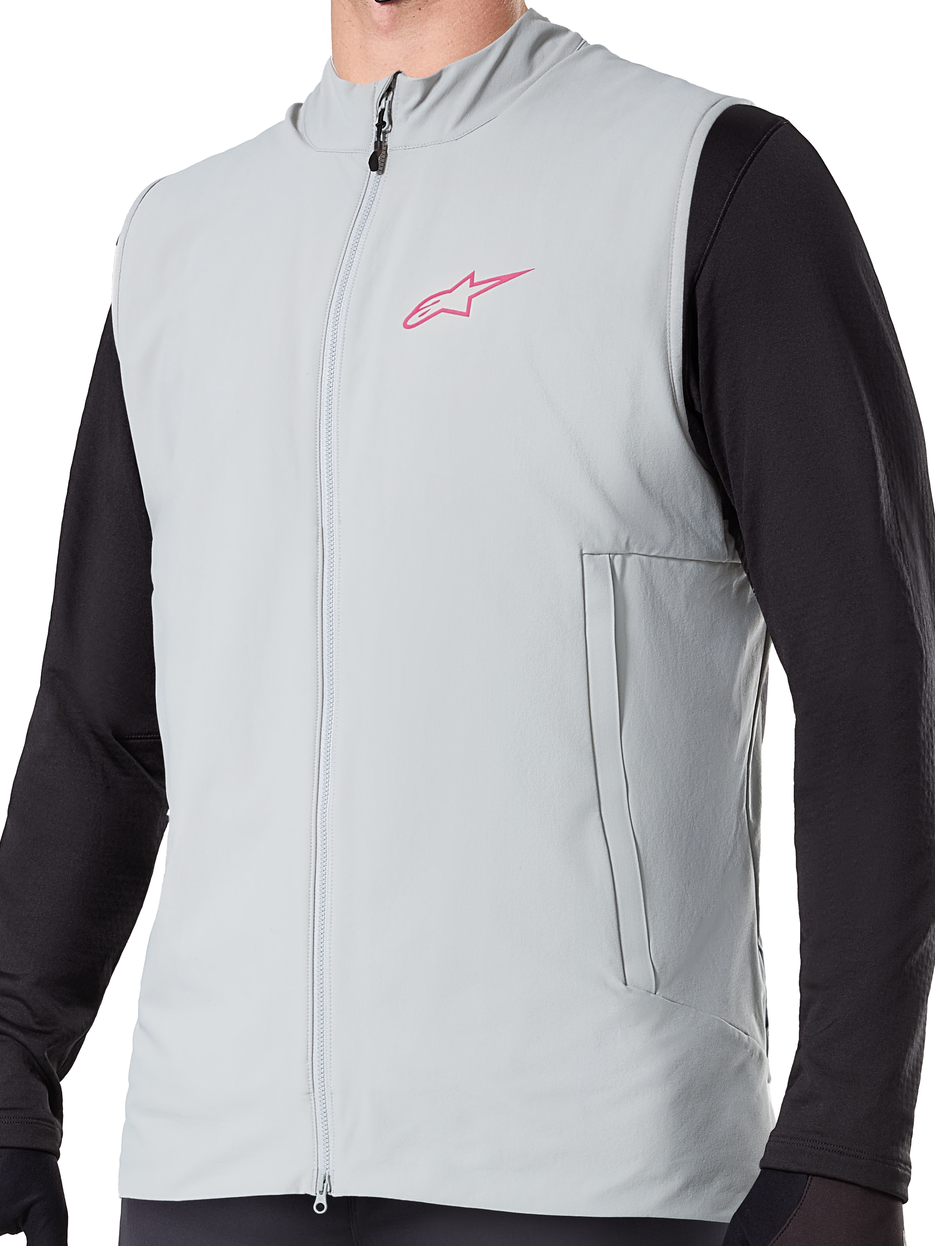 Alpinestars A-Dura Thermal Vest, colete de ciclismo isolado em cinzento Titanium, com logótipo de estrela cor-de-rosa no peito, usado sobre uma camisola preta de manga comprida, inclui um bolso vertical com fecho e fecho frontal completo, concebido para trilhos de BTT em climas frios