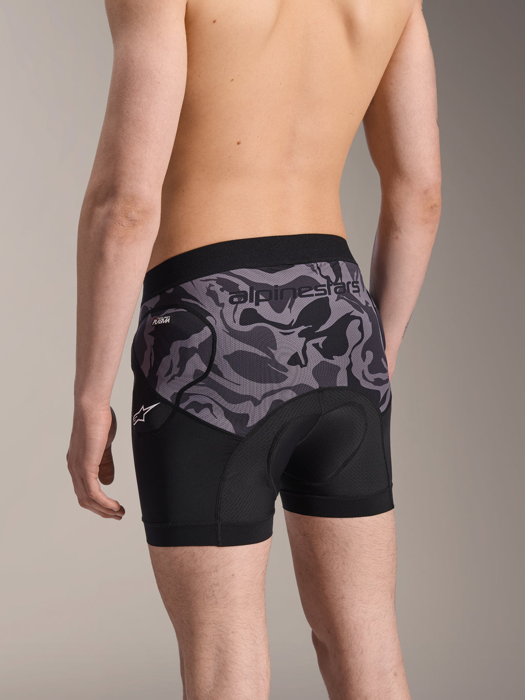 Boxers de Proteção Alpinestars A-Motion Plasma, calções de proteção para ciclismo em Black Camo, vista traseira mostrando o design ergonómico com proteção de anca Nucleon Plasma e almofada de camurça, material de malha respirável com logótipo Alpinestars no cós