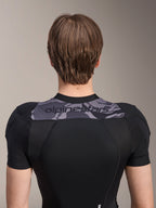 Casaco de Proteção Alpinestars A-Motion Plasma - Manga Curta, vista traseira do tronco superior, preto com painel camuflado cinzento nos ombros com logótipo Alpinestars, construção em malha elástica respirável para proteção de BTT