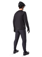 Alpinestars A-Dura Thermal Pant, Mountain Bike Pants, Black, shown from a rear perspective worn with a matching long-sleeve jersey, black MTB helmet, and gloves, technical cold-weather cycling gear