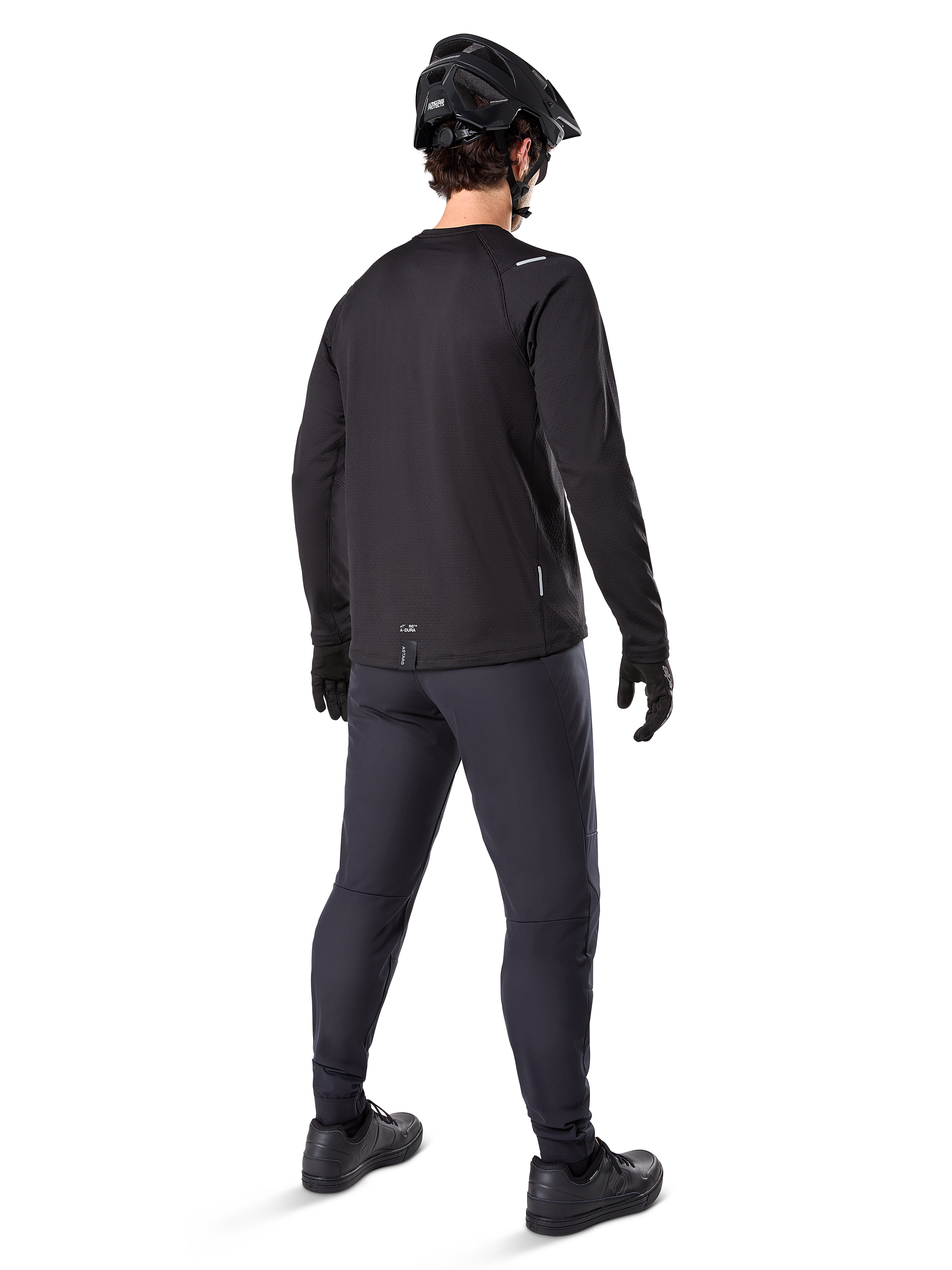 Alpinestars A-Dura Thermal Pant, Mountain Bike Pants, Black, shown from a rear perspective worn with a matching long-sleeve jersey, black MTB helmet, and gloves, technical cold-weather cycling gear