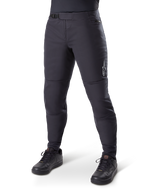 Alpinestars A-Dura Thermal Pant, Black Mountain Bike Pants, worn with black cycling shoes, featuring a ratchet waist closure, small white logo on the thigh, tapered fit for cold-weather riding