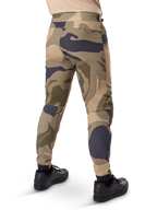 Alpinestars A-Dura Camo Pant, MTB Pants, Brown camouflage pattern with tan and dark grey accents, rear view shown with black sneakers, featuring tapered legs and elasticated cuffs, durable 2-way stretch fabric for mountain biking
