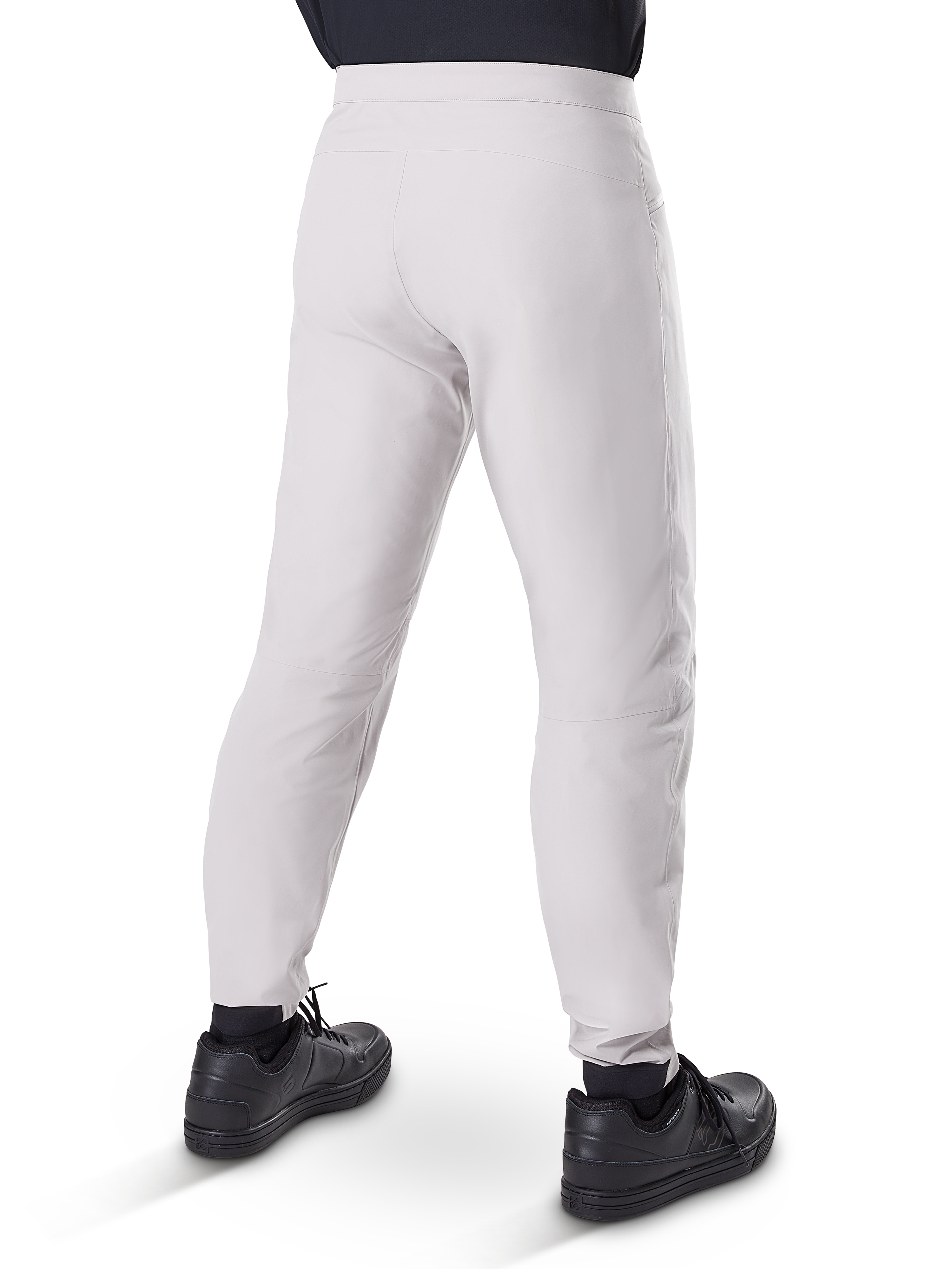 Calças Impermeáveis Alpinestars A-Dura, calças de ciclismo MTB, cinza Titanium, vista traseira mostrando as pernas afuniladas e os punhos elásticos, usadas com sapatos pretos, equipamento técnico impermeável para BTT