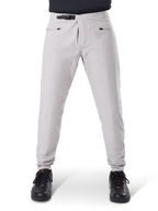 Calças Impermeáveis Alpinestars A-Dura, calças de ciclismo MTB, cinza Titanium, vista frontal, com fecho de catraca preto na cintura e dois bolsos com fecho de correr, punhos elásticos, usadas com sapatilhas pretas, equipamento técnico impermeável para mountain biking