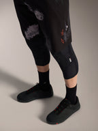 Calções Alpinestars A-Dura Ride Black Camo, equipamento de BTT com logótipo laranja, joelheiras e sapatos de ciclismo.