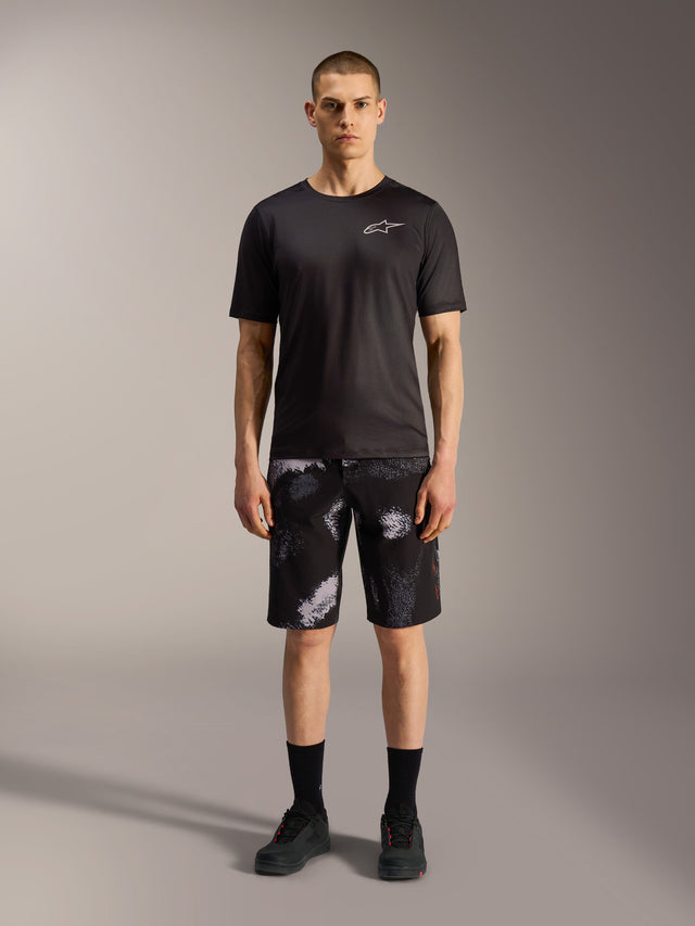 Calções Alpinestars A-Dura Ride em Black Camo, com t-shirt de performance preta para versatilidade em mountain bike.