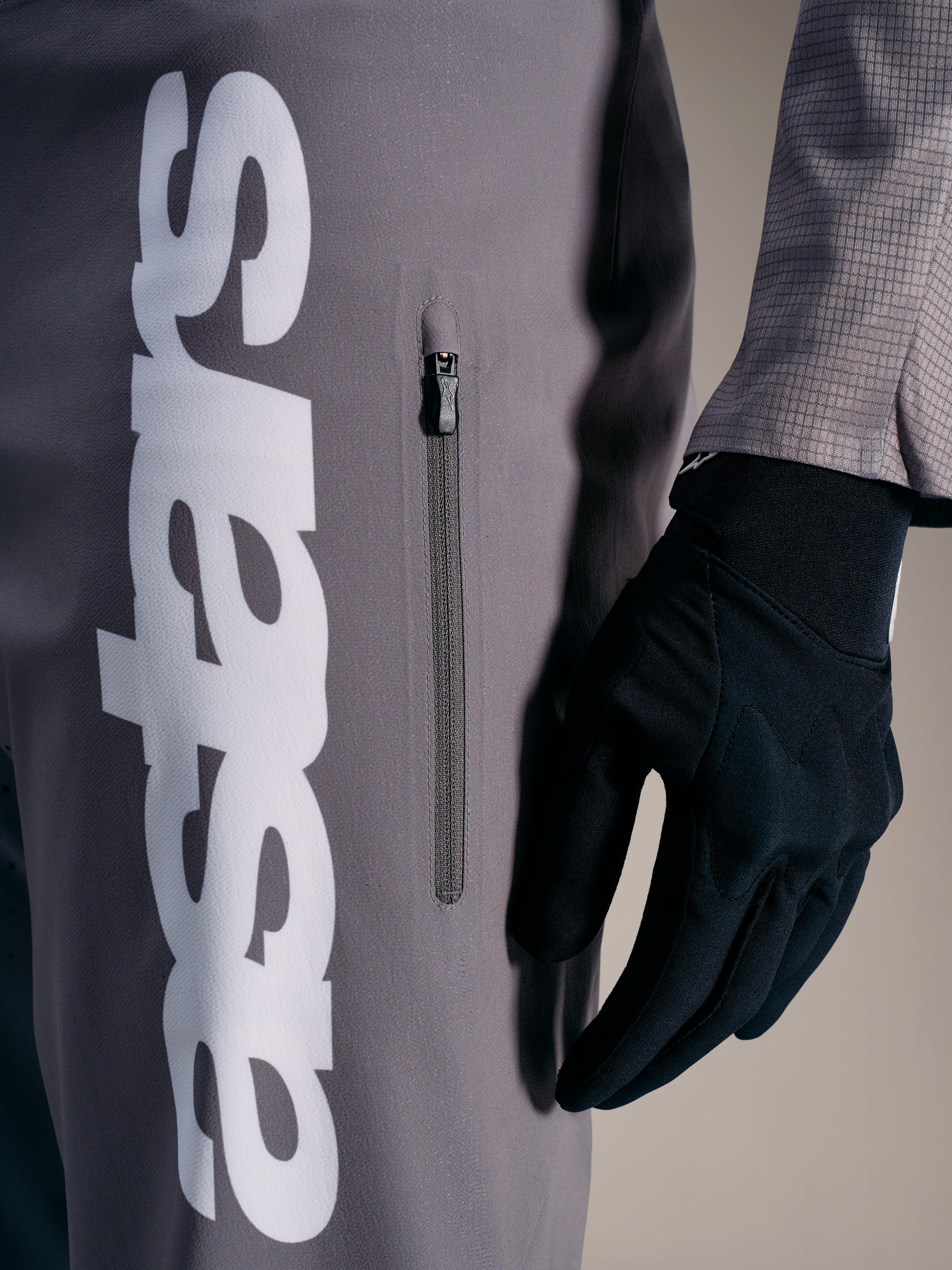 Calças Alpinestars A-Supra Elite em cinzento, logótipo branco e bolso vertical, para performance em BTT.