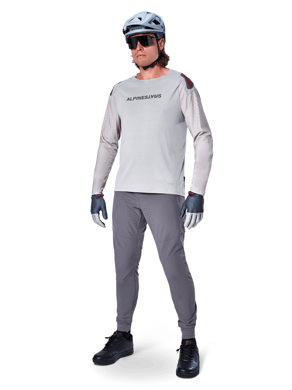 Alpinestars A-Aria Elite Pants, Dark Gray MTB Pants, worn by a rider with a light gray long-sleeve jersey and gray helmet, featuring laser-cut ventilation on the thighs and a tapered performance fit for mountain biking.