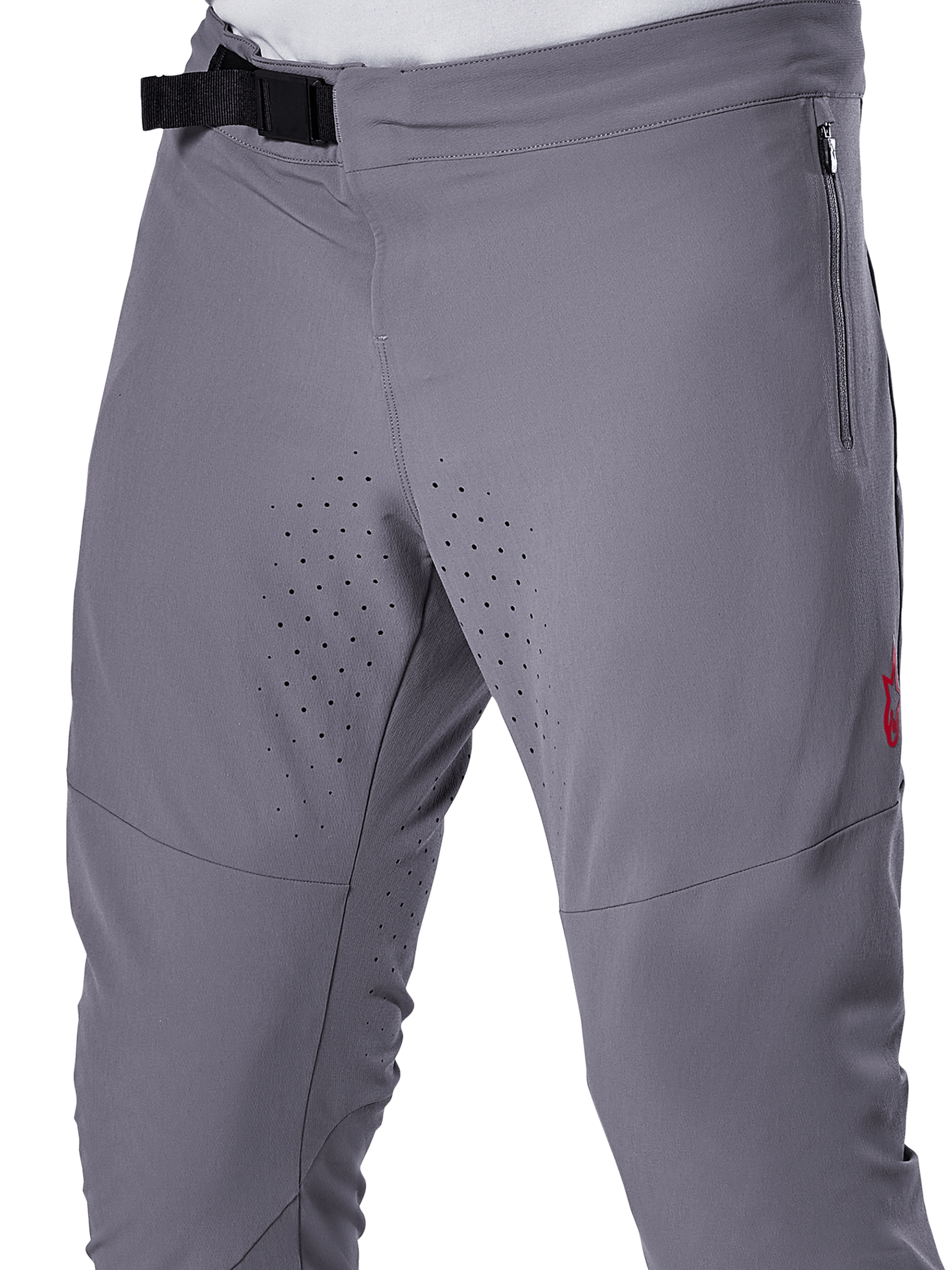 Alpinestars A-Aria Elite Pants, MTB Cycling Pants, Dark Gray, close-up view featuring the magnetic buckle closure, zippered side pocket, and laser-cut ventilation perforations on the inner thighs for trail riding performance.