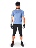 Calções Alpinestars A-Dura Elite, calções pretos de mountain bike, usados com uma t-shirt azul-claro, capacete preto, óculos de sol e joelheiras, vestuário profissional de ciclismo fora de estrada