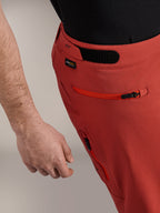 Alpinestars A-Dura Elite Shorts, cor de laranja escuro, grande plano do perfil lateral apresentando ajustador de cintura de gancho e laço, logótipo Cordura® e bolso lateral com fecho de correr, calções de mountain bike premium.