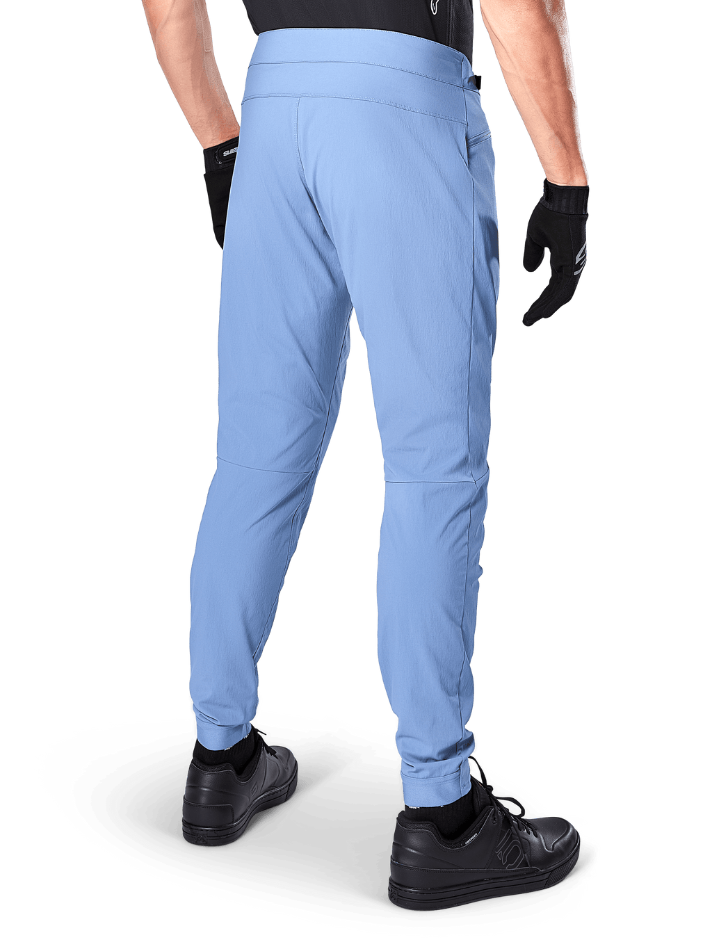 Alpinestars A-Dura Pants, calças de mountain bike, Azul Infinity, vista traseira mostrando o ajuste regular e os punhos elásticos, usadas com luvas pretas e calçado preto, vestuário de ciclismo durável com elasticidade em 2 direções