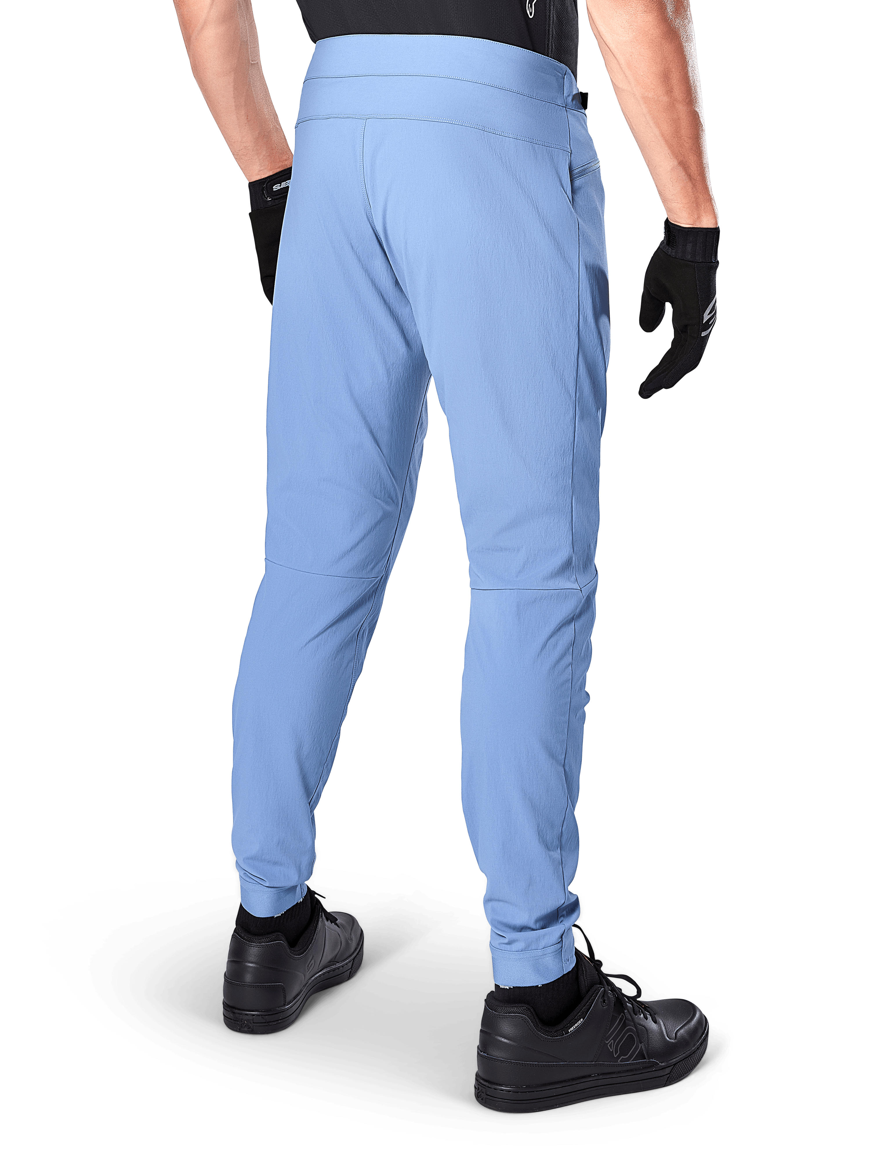Alpinestars A-Dura Pants, calças de mountain bike, Azul Infinity, vista traseira mostrando o ajuste regular e os punhos elásticos, usadas com luvas pretas e calçado preto, vestuário de ciclismo durável com elasticidade em 2 direções