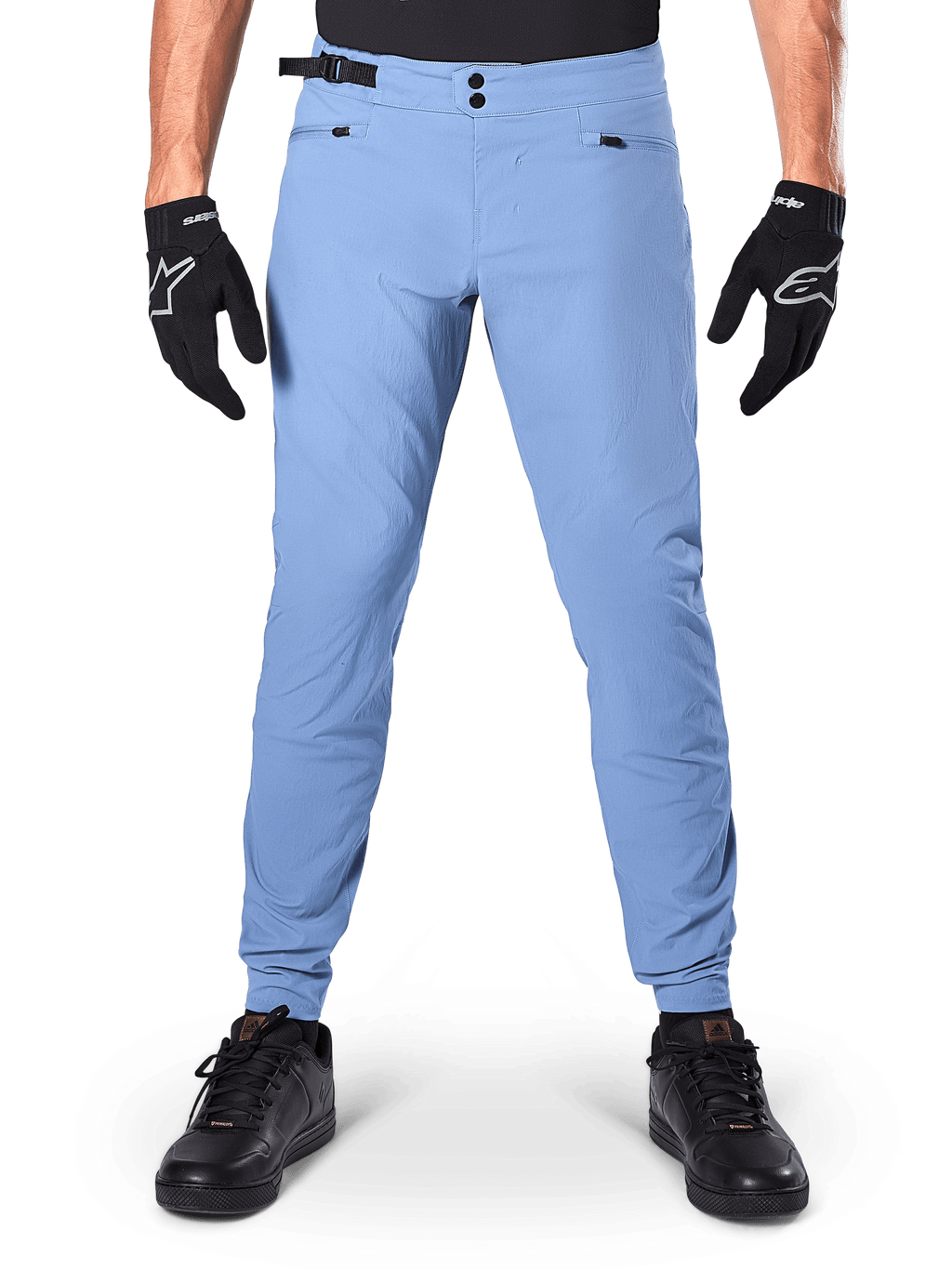 Calças Alpinestars A-Dura, calças de MTB, Infinity Blue, calças de mountain bike em azul claro com fecho de pressão duplo e bolsos com zíper, usadas com luvas pretas e sapatos pretos, ajuste regular com punhos elásticos